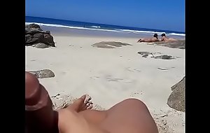 Batendo punheta na frente de duas mulheres em praia de nudismo