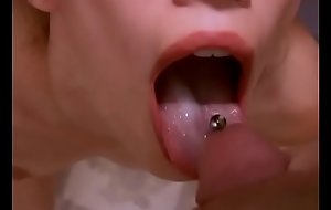 PIGTAILED CUTIE TAKES THICK LOAD ON HER OUTSTRETCHED PIERCED TONGUE CLOSEUP